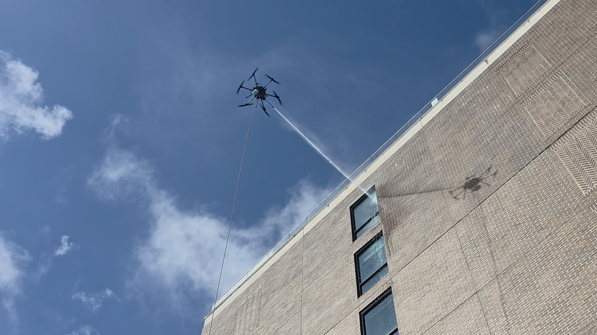 Drone washing a high commercial building facade